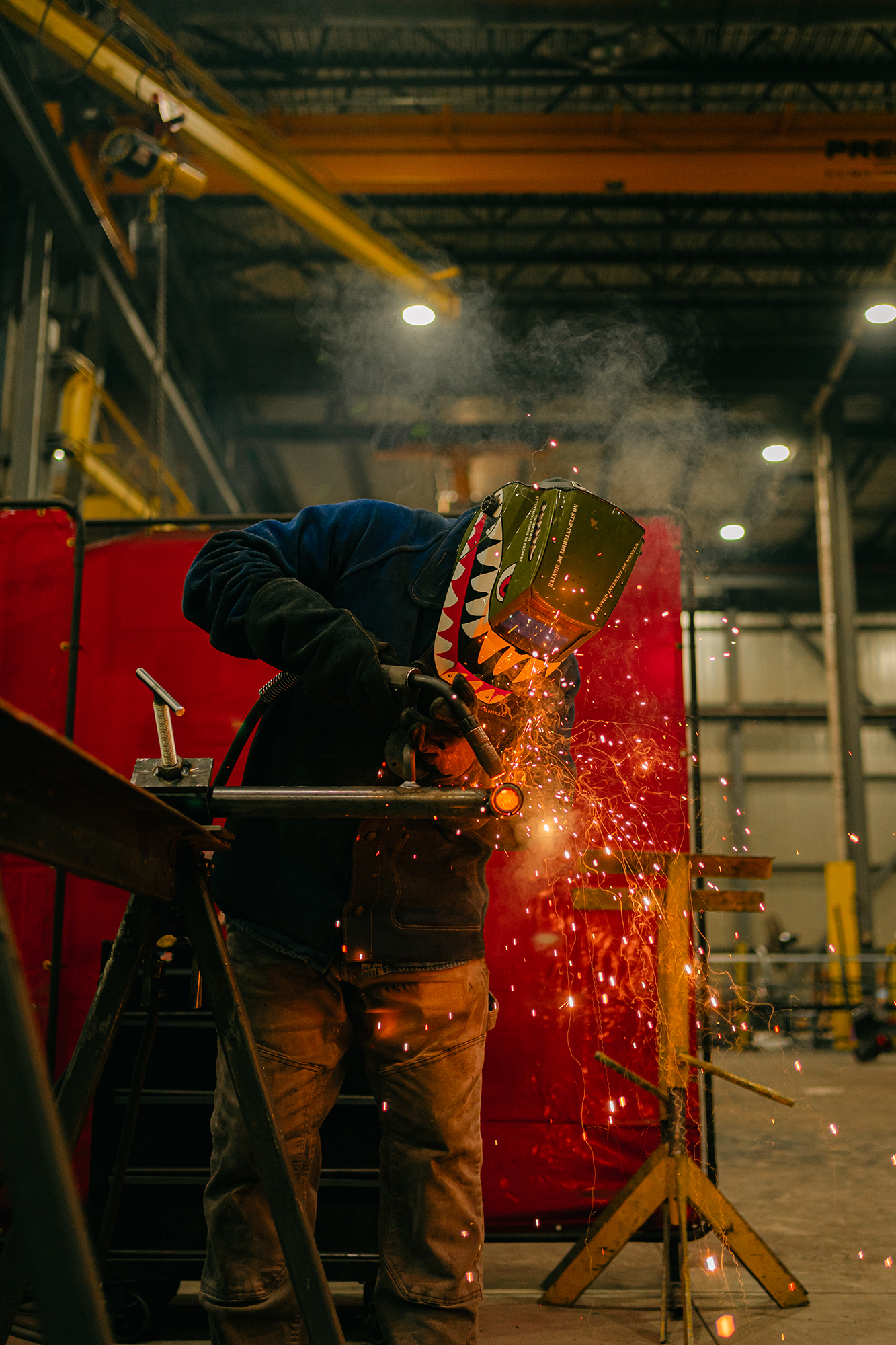 Homme qui fait de la soudure dans une usine